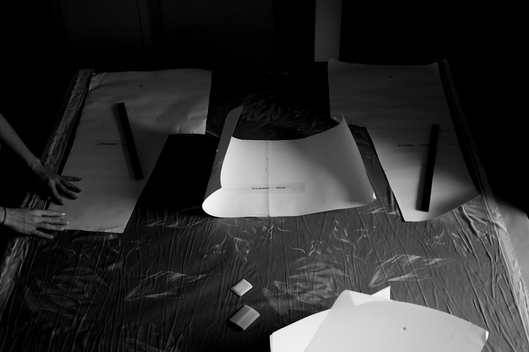 clutheytheyered desk witheyh papers and laptheyop